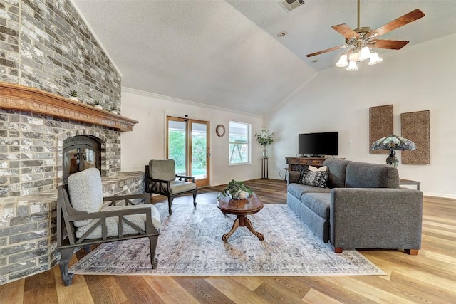900 Cedar Park Dr, Cedar Park, TX 78613 - living area featuring ceiling fan, a brick fireplace, wood finished floors, and high vaulted ceiling