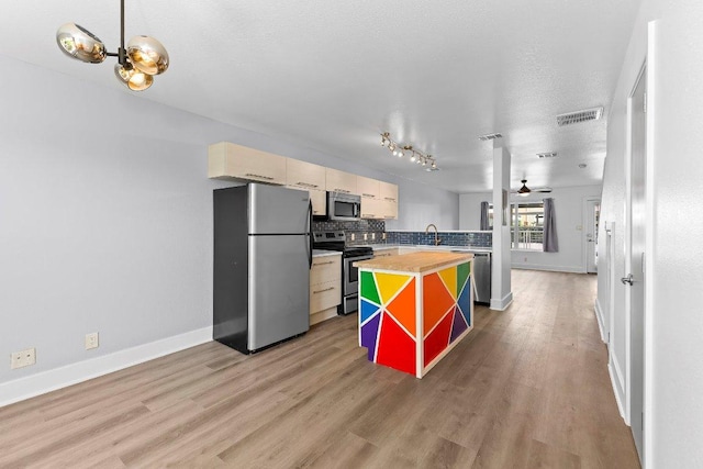 1101 Grove Blvd Unit 803, Austin, TX 78741 - kitchen featuring stainless steel appliances, decorative backsplash, light wood-type flooring, ceiling fan, and baseboards