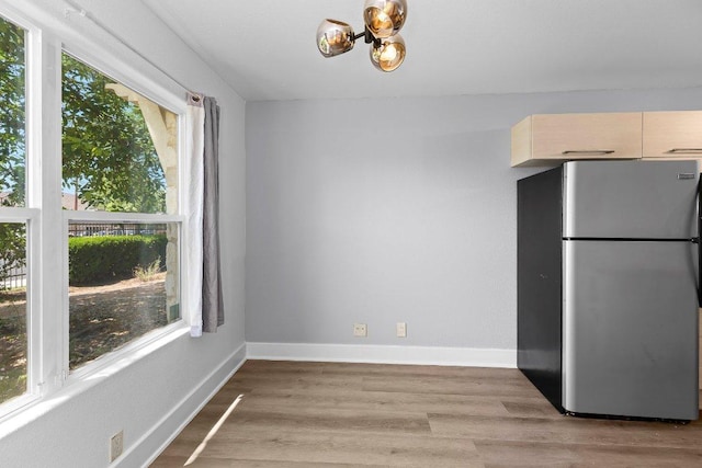 1101 Grove Blvd Unit 803, Austin, TX 78741 - unfurnished dining area with a chandelier, light wood-style flooring, and baseboards