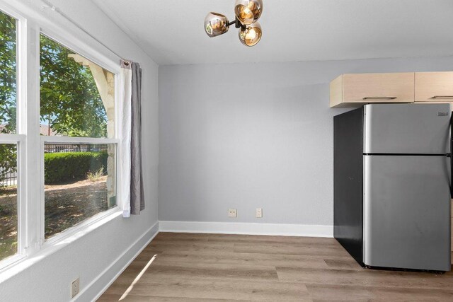 1101 Grove Blvd Unit 803, Austin, TX 78741 - unfurnished dining area featuring a chandelier, light wood-style floors, and baseboards