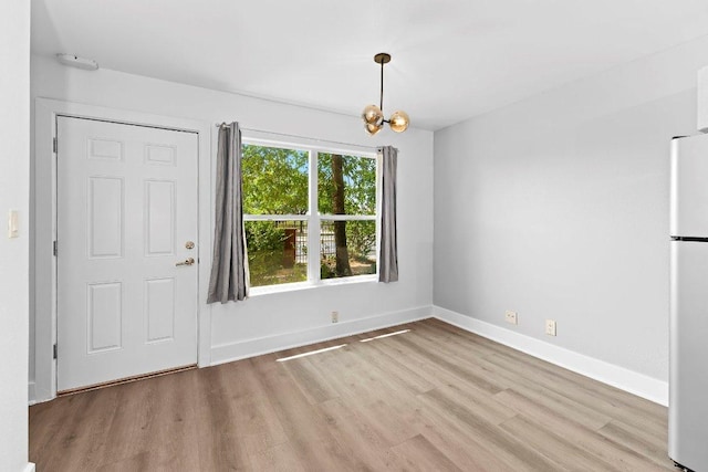 1101 Grove Blvd Unit 803, Austin, TX 78741 - unfurnished dining area with light wood-style floors, a chandelier, and baseboards