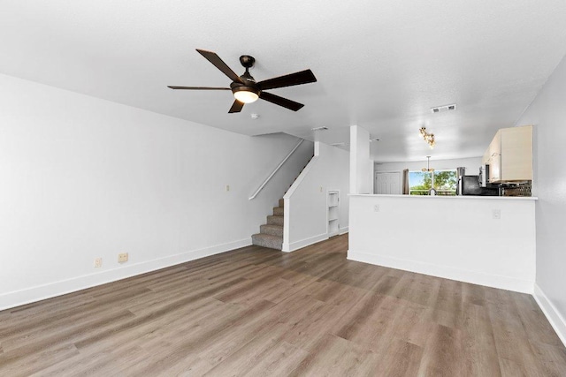 1101 Grove Blvd Unit 803, Austin, TX 78741 - unfurnished living room featuring light wood-style floors, a ceiling fan, baseboards, and stairway
