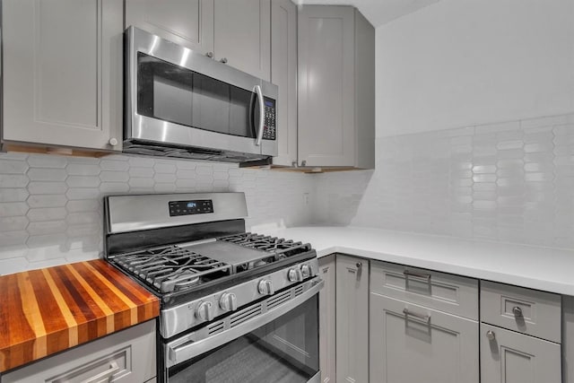 4406 Dove Springs Dr, Austin, TX 78744 - kitchen with appliances with stainless steel finishes, gray cabinets, tasteful backsplash, and wooden counters