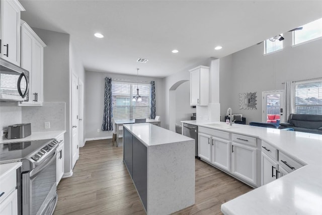 302 Emory Fields Dr, Hutto, TX 78634 - kitchen with appliances with stainless steel finishes, a sink, arched walkways, light countertops, and recessed lighting