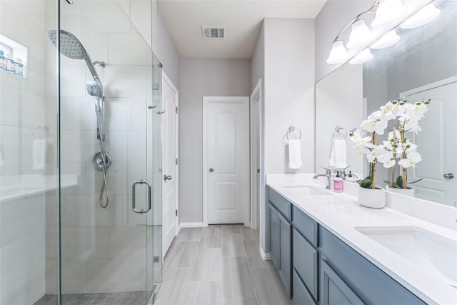 302 Emory Fields Dr, Hutto, TX 78634 - bathroom with a shower stall, double vanity, and baseboards