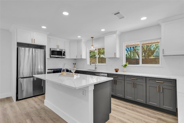 11602 Big Trl, Austin, TX 78759 - kitchen with stainless steel appliances, white cabinets, tasteful backsplash, light wood-style floors, and recessed lighting