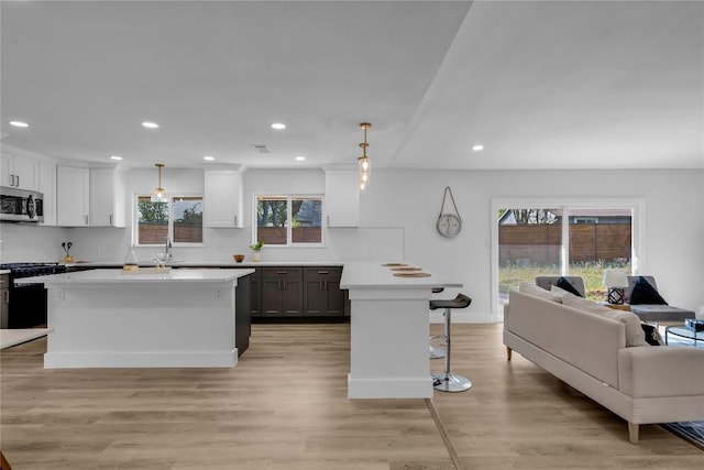 11602 Big Trl, Austin, TX 78759 - kitchen with stainless steel microwave, a kitchen breakfast bar, open floor plan, gas range, and backsplash