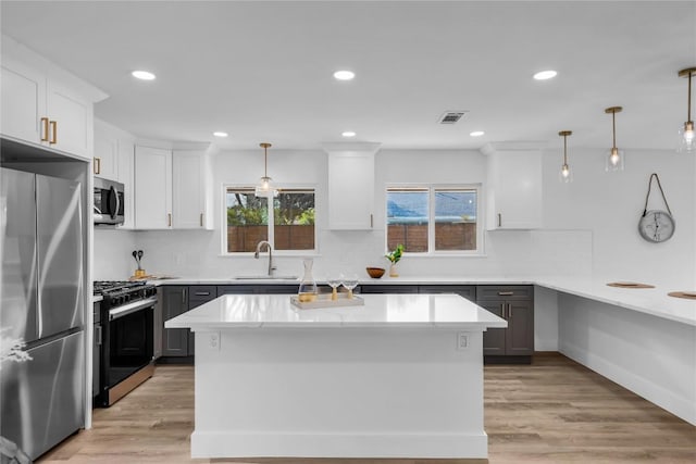11602 Big Trl, Austin, TX 78759 - kitchen featuring appliances with stainless steel finishes, light wood-style flooring, white cabinetry, recessed lighting, and tasteful backsplash