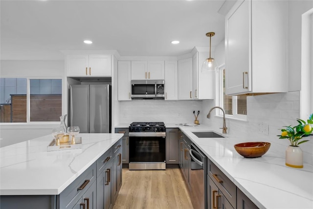 11602 Big Trl, Austin, TX 78759 - kitchen featuring stainless steel appliances, a sink, gray cabinetry, white cabinetry, and light stone countertops
