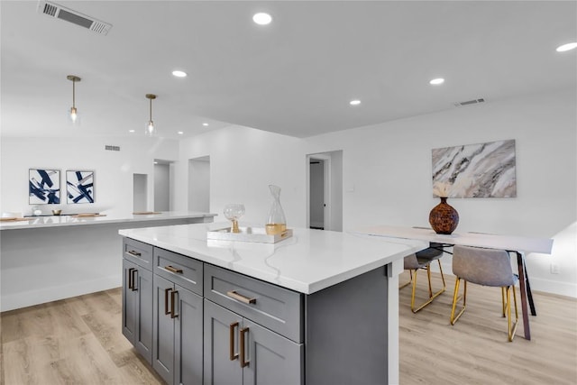 11602 Big Trl, Austin, TX 78759 - kitchen featuring gray cabinets, light wood-type flooring, a center island, decorative light fixtures, and recessed lighting