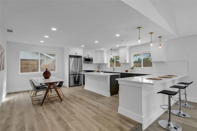 11602 Big Trl, Austin, TX 78759 - kitchen featuring stainless steel appliances, white cabinetry, a breakfast bar, a peninsula, and recessed lighting