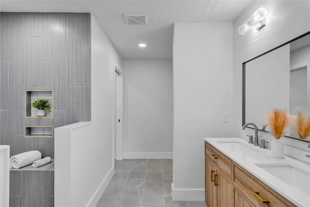 11602 Big Trl, Austin, TX 78759 - full bathroom with double vanity, baseboards, marble look tiles, and recessed lighting