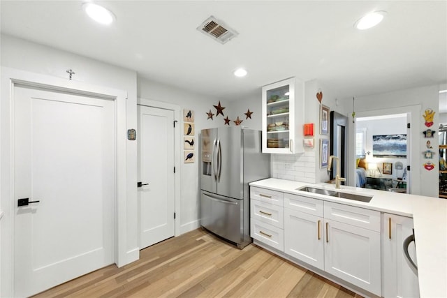 2406 Shiloh Dr, Austin, TX 78745 - kitchen featuring stainless steel fridge with ice dispenser, a sink, light wood-type flooring, light countertops, and recessed lighting