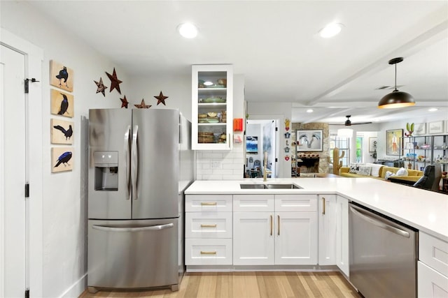 2406 Shiloh Dr, Austin, TX 78745 - kitchen with stainless steel appliances, glass insert cabinets, light countertops, a sink, and light wood-style floors