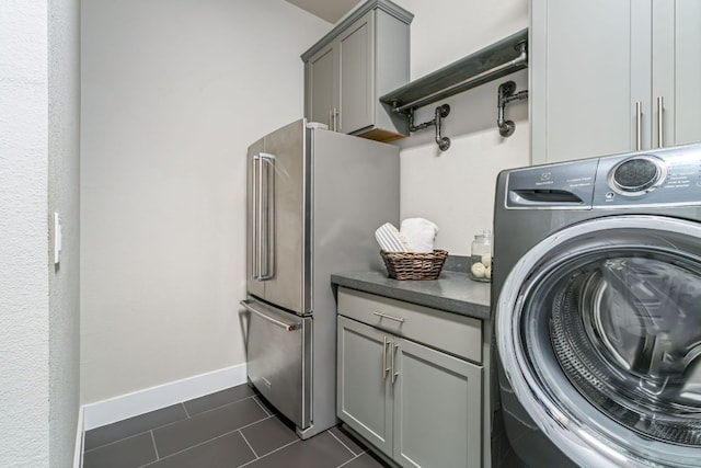 1280 Lucca Dr, Dripping Springs, TX 78620 - laundry area with washer / dryer, dark tile patterned floors, cabinet space, and baseboards