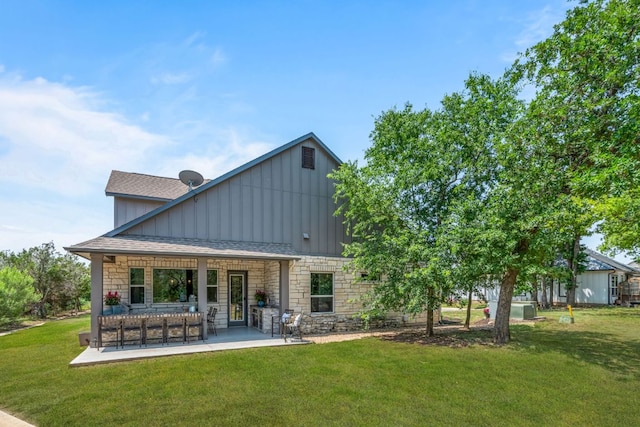 1280 Lucca Dr, Dripping Springs, TX 78620 - back of house with board and batten siding, stone siding, and a lawn
