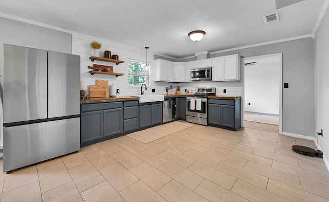 3506 Oakridge Blvd, Harker Heights, TX 76548 - kitchen with appliances with stainless steel finishes, crown molding, white cabinetry, open shelves, and gray cabinetry