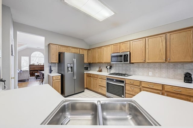 5405 Apache Creek Cv, Austin, TX 78735 - kitchen featuring appliances with stainless steel finishes, vaulted ceiling, light countertops, tasteful backsplash, and a sink