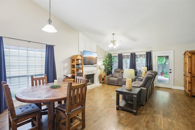 17008 Cactus Blossom Dr, Pflugerville, TX 78660 - dining space with vaulted ceiling, ceiling fan, wood-type flooring, and a fireplace with raised hearth
