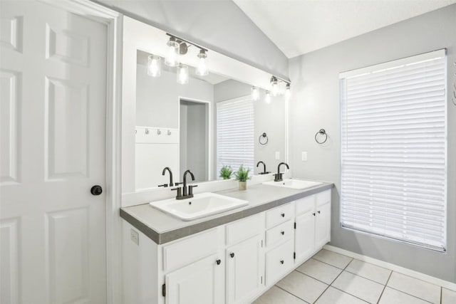 17008 Cactus Blossom Dr, Pflugerville, TX 78660 - bathroom with double vanity, tile patterned flooring, lofted ceiling, and baseboards
