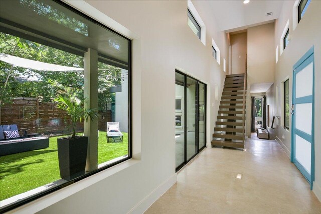 1904 E 9th St, Austin, TX 78702 - hall with concrete flooring, baseboards, a high ceiling, and stairs