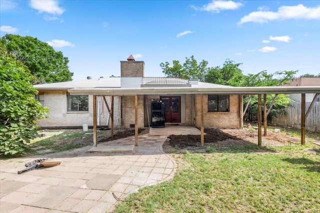 1307 Meadgreen Dr, Austin, TX 78758 - rear view of property with brick siding, a chimney, french doors, a patio area, and a carport