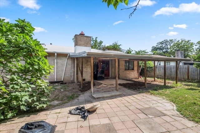 1307 Meadgreen Dr, Austin, TX 78758 - rear view of house featuring a chimney, brick siding, and a patio area