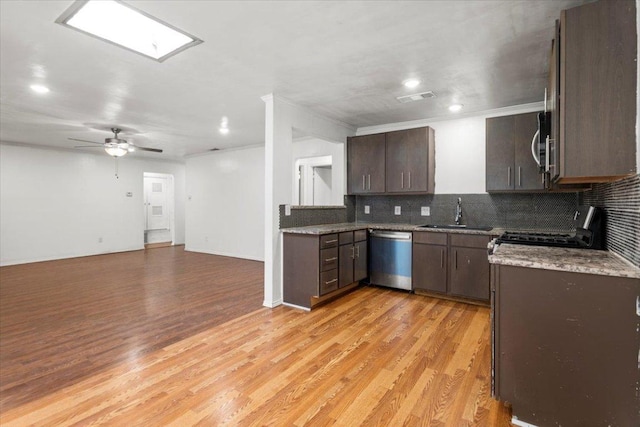 1307 Meadgreen Dr, Austin, TX 78758 - kitchen with appliances with stainless steel finishes, a sink, decorative backsplash, dark brown cabinetry, and light wood-style floors