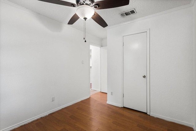 1307 Meadgreen Dr, Austin, TX 78758 - unfurnished bedroom with wood finished floors, a textured ceiling, baseboards, ornamental molding, and a ceiling fan