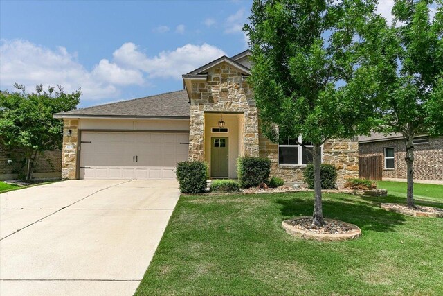 4333 Buffalo Ford Rd, Georgetown, TX 78628 - view of front of home featuring stone siding, concrete driveway, an attached garage, and a front yard