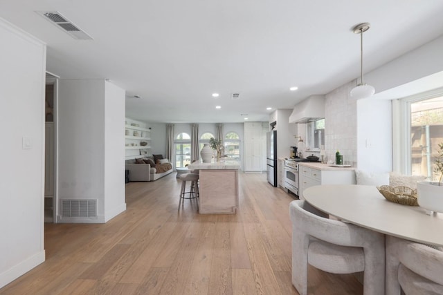 7905 Havenwood Dr, Austin, TX 78759 - kitchen with stainless steel appliances, open floor plan, a kitchen breakfast bar, plenty of natural light, and recessed lighting