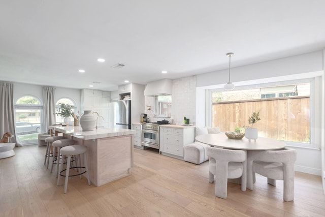 7905 Havenwood Dr, Austin, TX 78759 - kitchen with stainless steel appliances, white cabinets, plenty of natural light, and recessed lighting