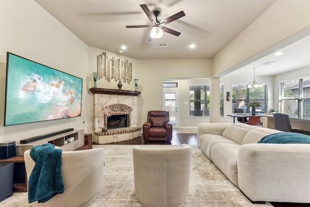 2415 Berkshire Way, Cedar Park, TX 78613 - living room featuring a chandelier, a ceiling fan, light wood finished floors, a stone fireplace, and recessed lighting