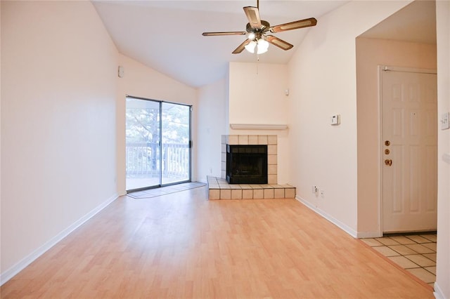 2450 Wickersham Ln Unit 718, Austin, TX 78741 - unfurnished living room with light wood-style floors, a ceiling fan, a tile fireplace, baseboards, and high vaulted ceiling