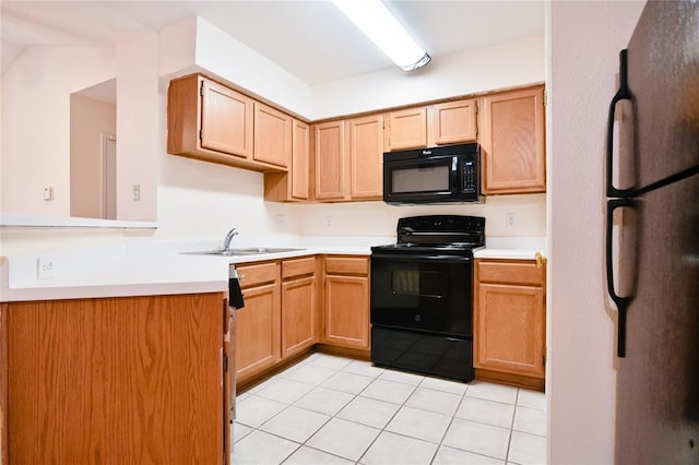 2450 Wickersham Ln Unit 718, Austin, TX 78741 - kitchen featuring black appliances, a sink, light tile patterned floors, and light countertops