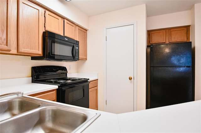 2450 Wickersham Ln Unit 718, Austin, TX 78741 - kitchen featuring black appliances, a sink, light countertops, and light brown cabinets