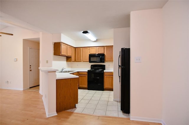 2450 Wickersham Ln Unit 718, Austin, TX 78741 - kitchen with black appliances, a sink, a peninsula, and light countertops