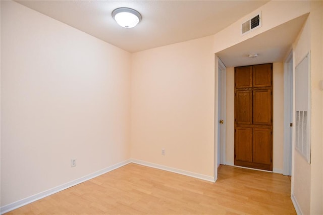 2450 Wickersham Ln Unit 718, Austin, TX 78741 - unfurnished room with light wood finished floors, baseboards, and a smoke detector