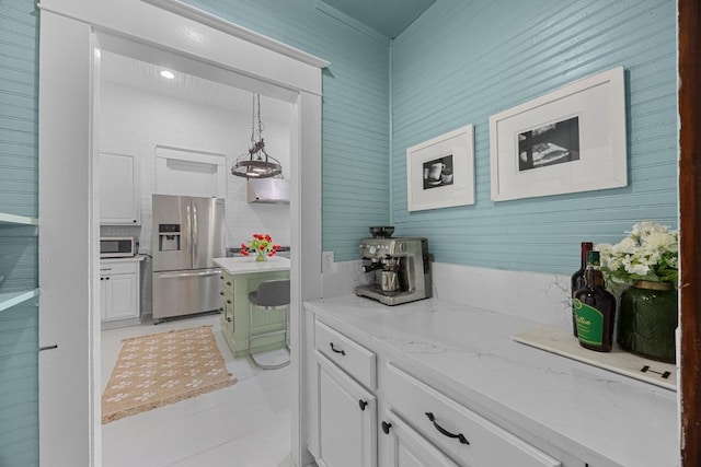 1502 S Elm St, Georgetown, TX 78626 - kitchen with appliances with stainless steel finishes, white cabinets, light stone counters, and hanging light fixtures