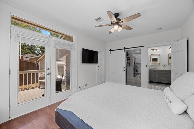 1502 S Elm St, Georgetown, TX 78626 - bedroom with a barn door, access to exterior, wood finished floors, and a ceiling fan