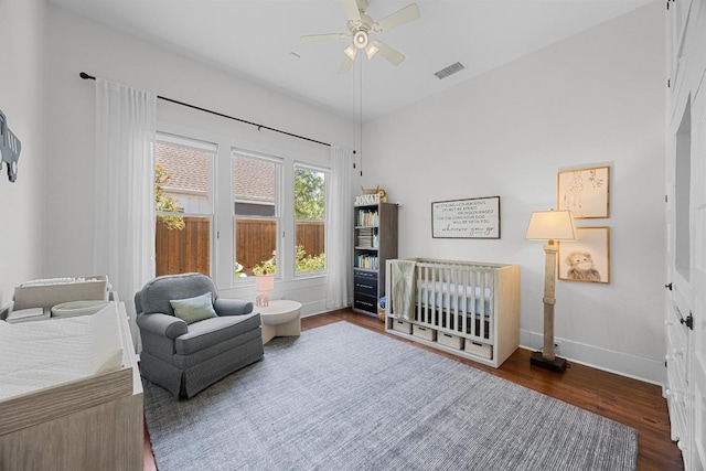 1502 S Elm St, Georgetown, TX 78626 - bedroom with wood finished floors, a ceiling fan, and a nursery area
