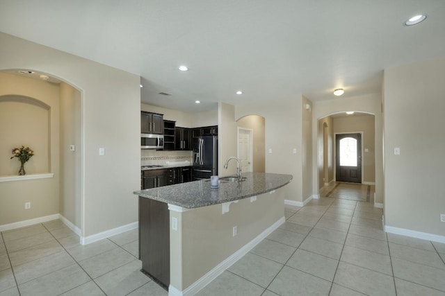 2937 Castellan Ln, Round Rock, TX 78665 - kitchen featuring stainless steel appliances, light tile patterned floors, an island with sink, light stone counters, and recessed lighting