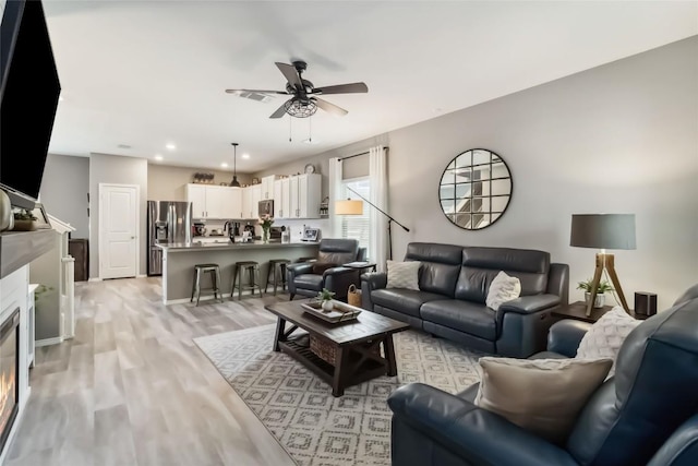 10901 Rome Ave, Austin, TX 78747 - living area featuring a ceiling fan, light wood-type flooring, a glass covered fireplace, and recessed lighting