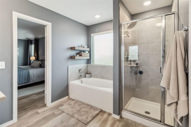 10901 Rome Ave, Austin, TX 78747 - ensuite bathroom featuring a bath, a stall shower, and wood finished floors