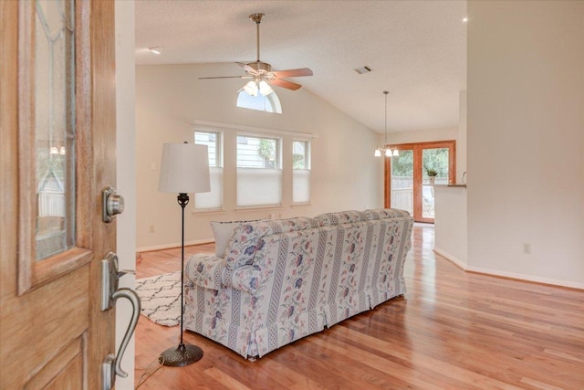 7925 Wheel Rim Cir, Austin, TX 78749 - living area featuring vaulted ceiling, light wood finished floors, ceiling fan, baseboards, and a chandelier