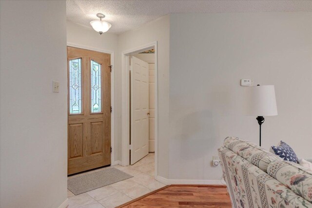 7925 Wheel Rim Cir, Austin, TX 78749 - foyer entrance with a textured ceiling, baseboards, and light wood-style floors