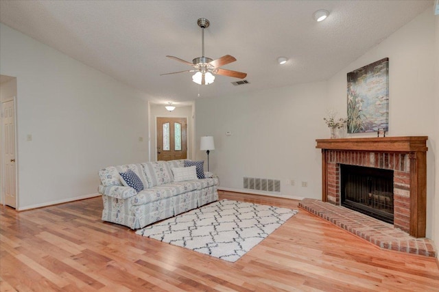7925 Wheel Rim Cir, Austin, TX 78749 - living area featuring wood finished floors, a ceiling fan, a brick fireplace, and baseboards
