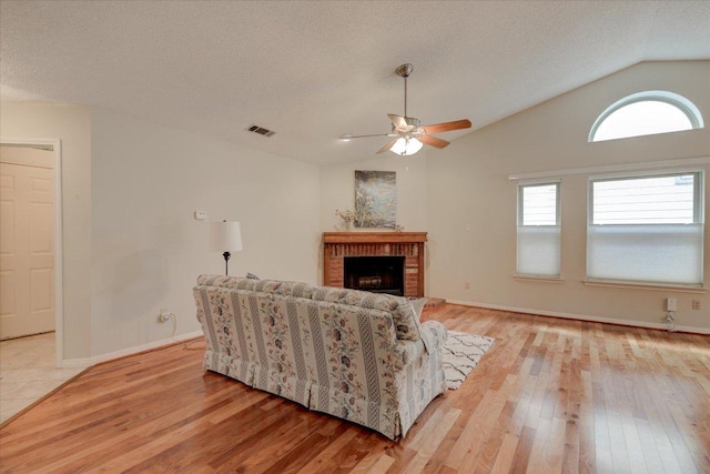 7925 Wheel Rim Cir, Austin, TX 78749 - living room with vaulted ceiling, light wood-style floors, ceiling fan, a fireplace, and baseboards