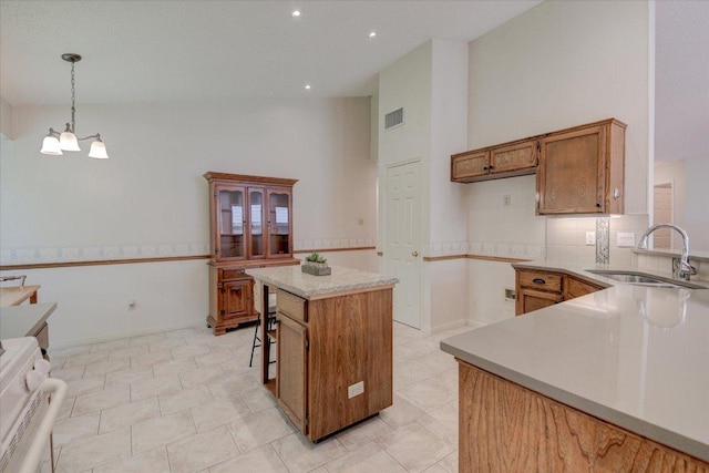 7925 Wheel Rim Cir, Austin, TX 78749 - kitchen featuring a sink, brown cabinetry, a chandelier, light countertops, and a high ceiling