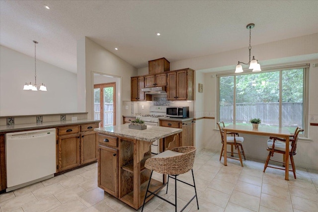 7925 Wheel Rim Cir, Austin, TX 78749 - kitchen with white appliances, under cabinet range hood, vaulted ceiling, brown cabinetry, and a kitchen island